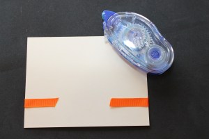 Ad adhesive to ribbon and adher to fron of card and wrap excess around back of card.